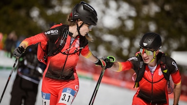Two ski mountaineering athletes in the handoff area of the 2025 ISMF World Championships mixed relay race.