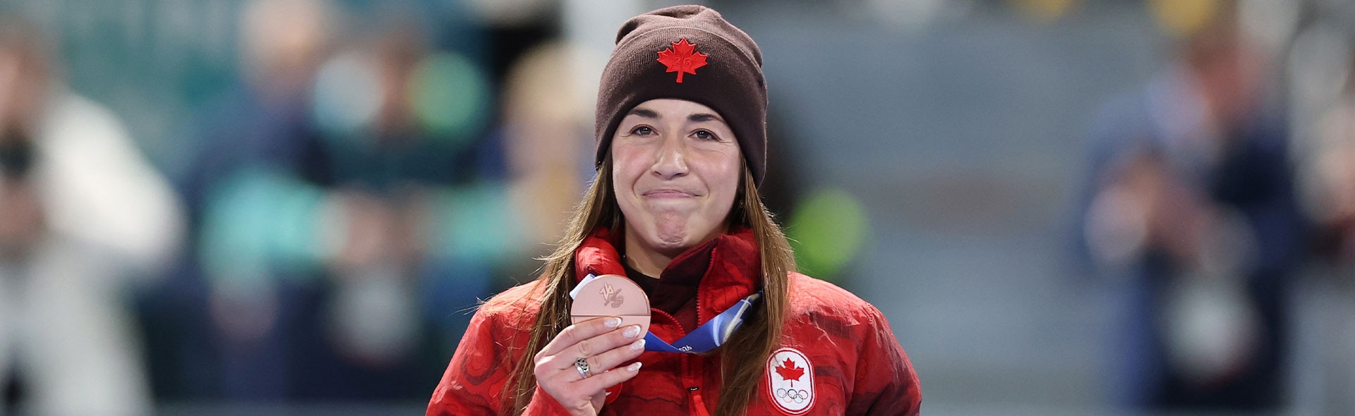 Valerie Maltais holding bronze medal