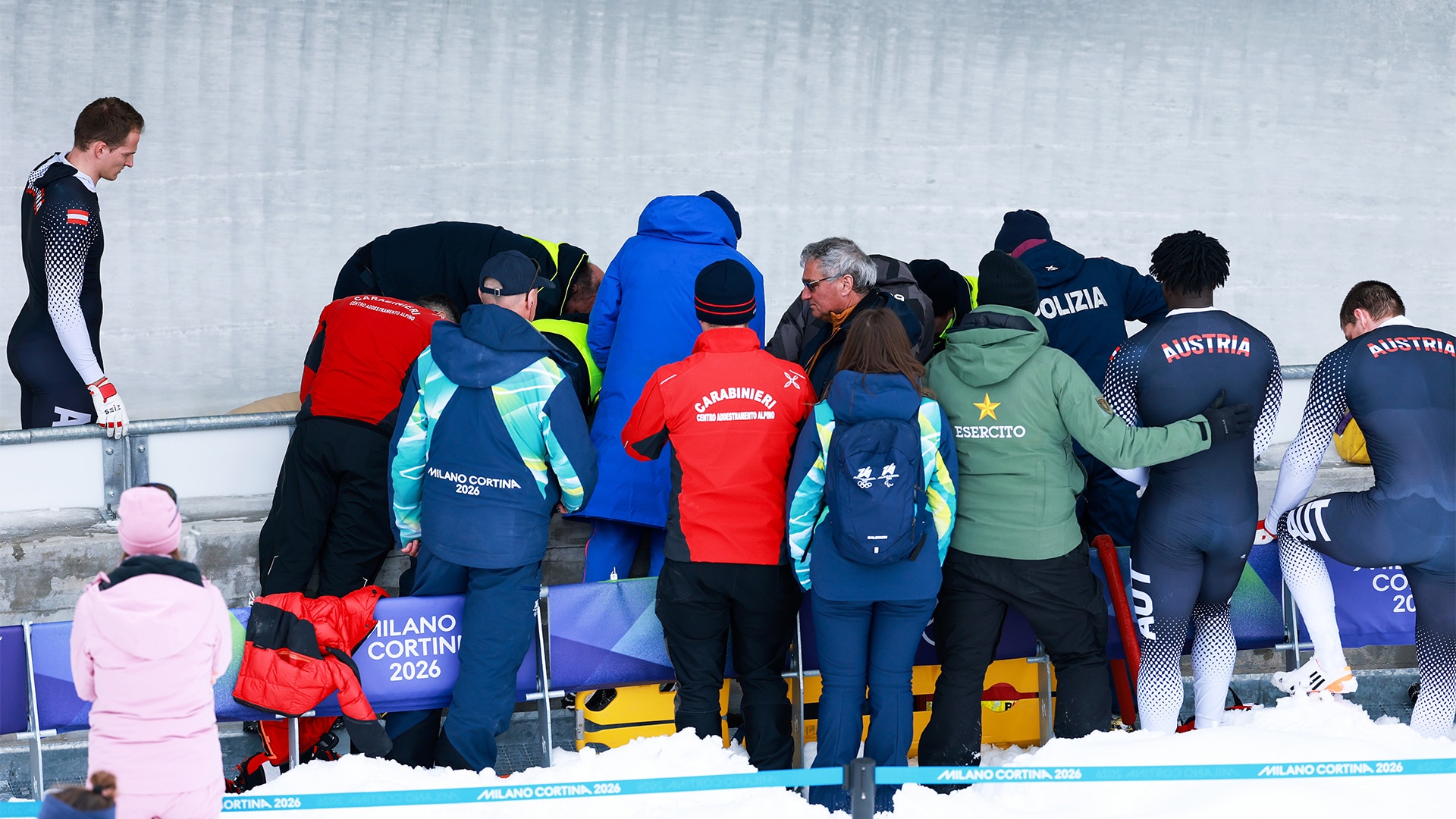 Crowd gathers around flipped Austrian sled on track