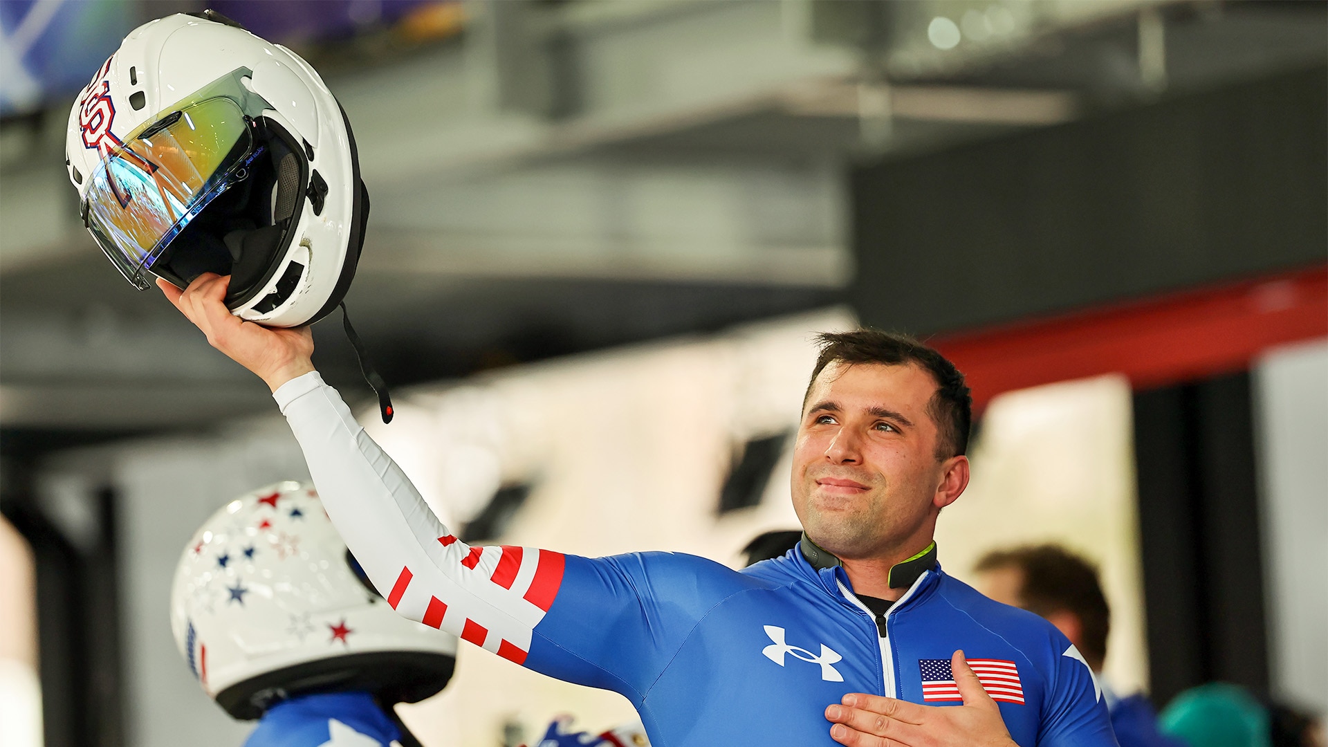 Frank Del Duca holds helmet up in right hand