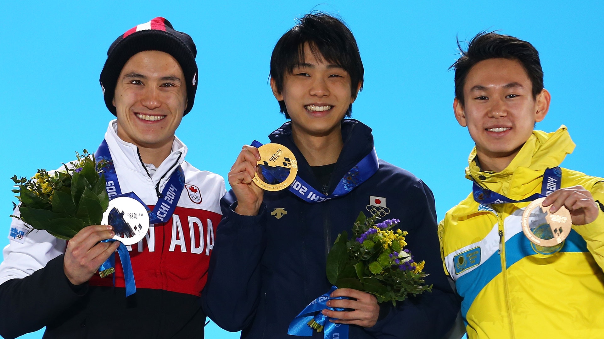 Patrick Chan, Yuzuru Hanyu, and Denis Ten receive their Olympic medals following the men's singles figure skating free skate at the 2014 Winter Olympics in Sochi, Russia.