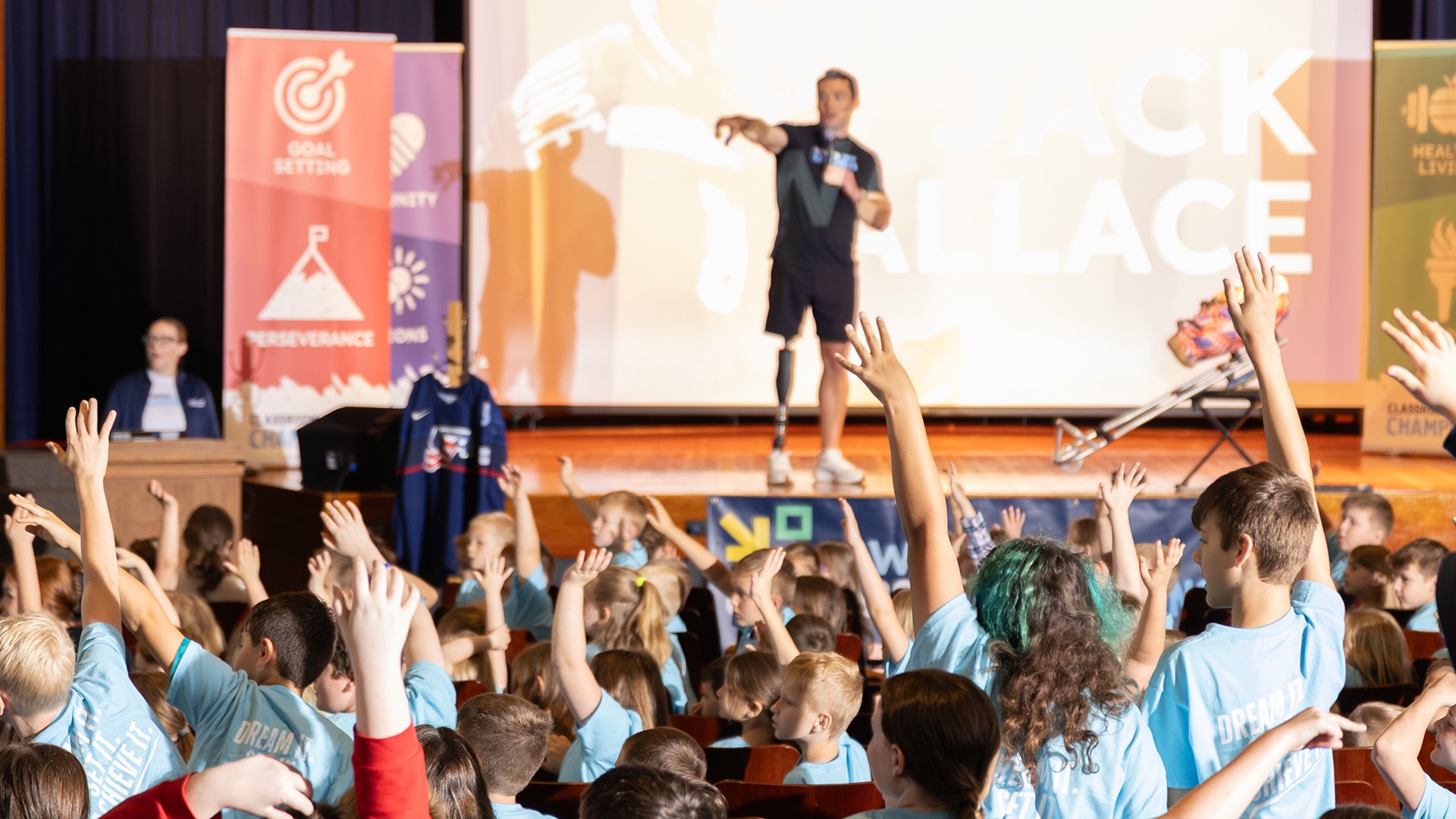 Jack Wallace onstage speaking to his mentees