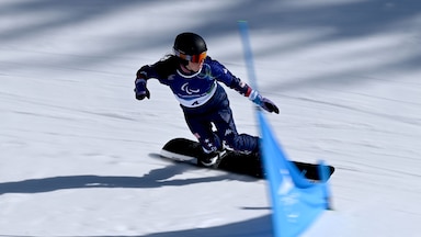 Kate Delson races past a gate at the Milan Cortina Paralympics.