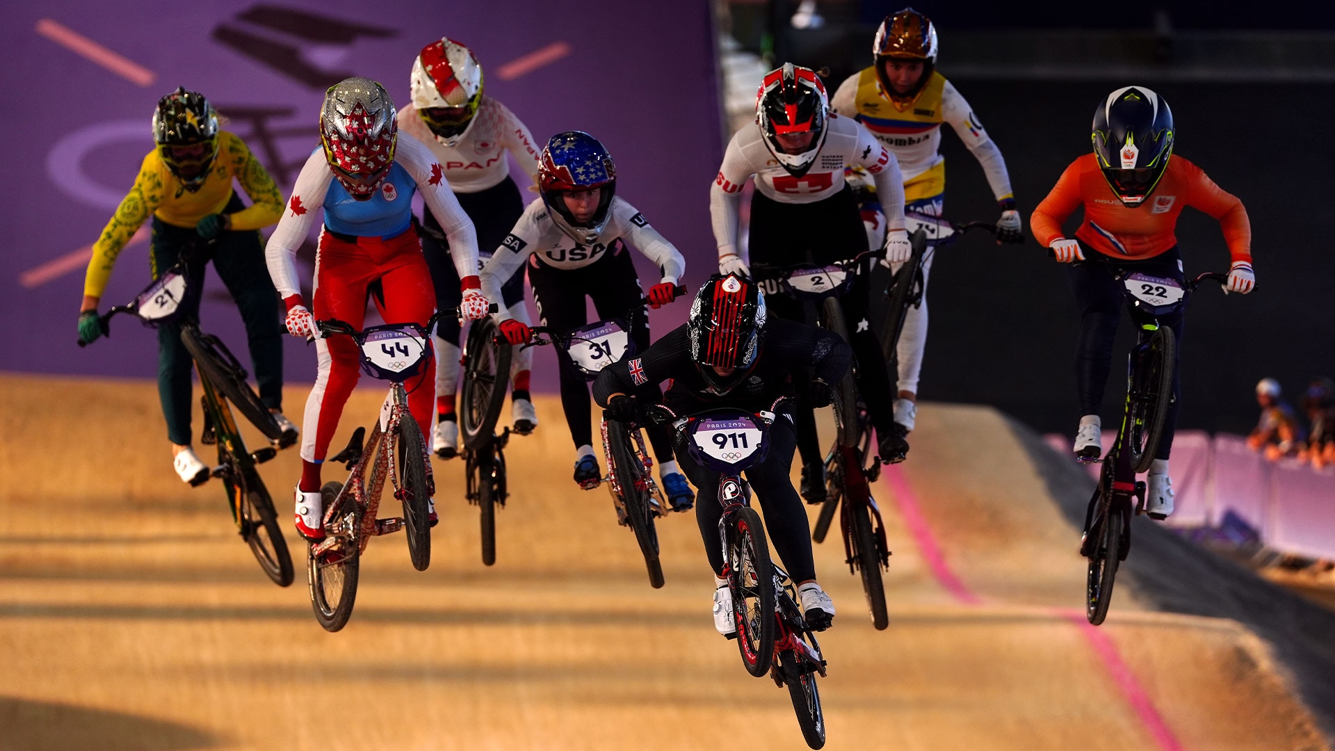 BMX racers ride together to the finish line.