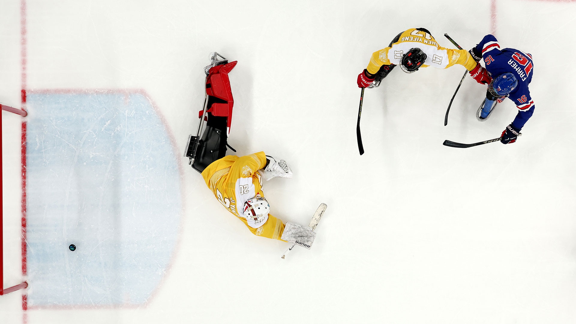 Declan Farmer, wearing a blue Team USA jersey, avoids a Chinese defender and plants the puck behind China's goalie to complete his hat trick