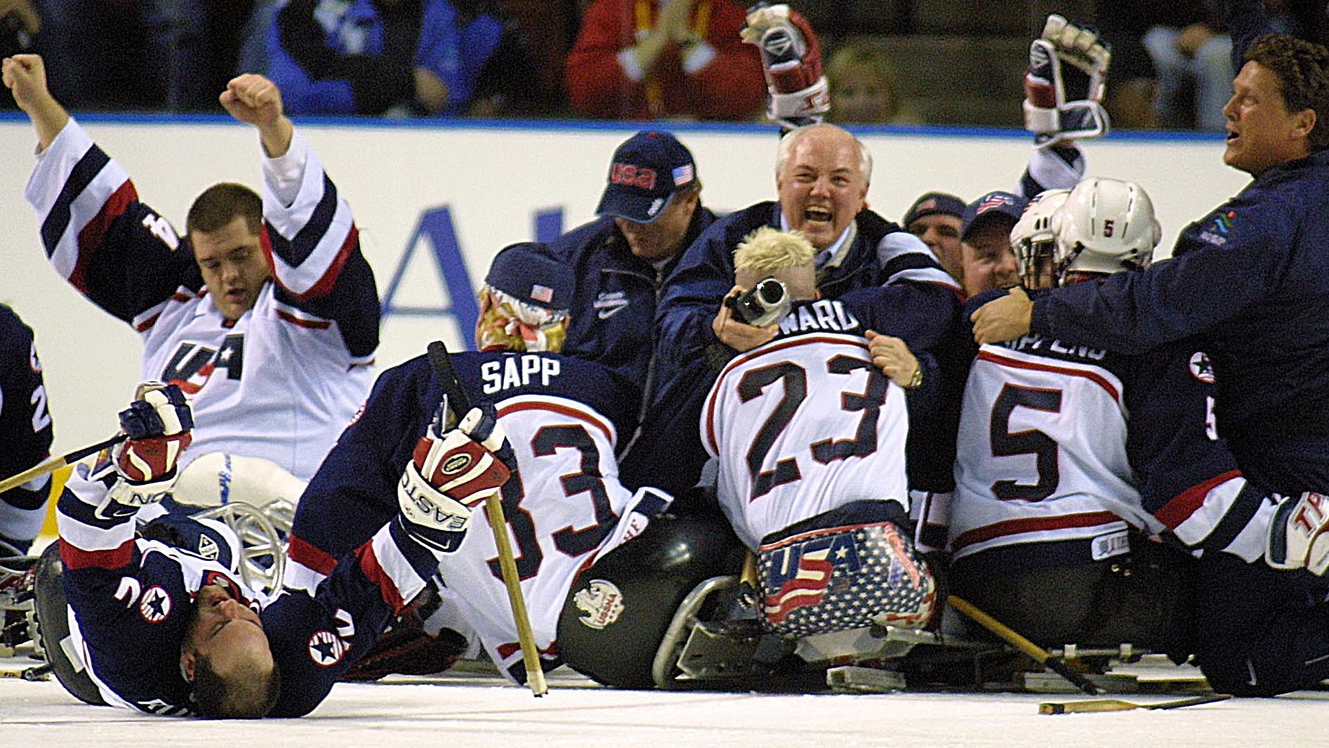 U.S. players and staff pile on top of each other on the ice to celebrate their win