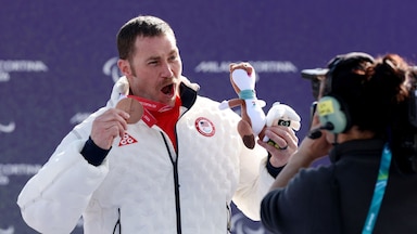 Mike Schultz smiles holding his bronze medal.