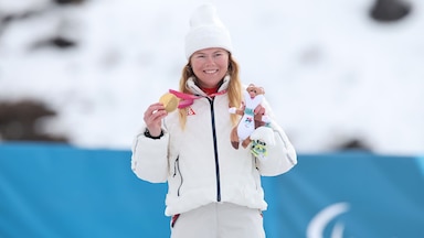 Sydney Peterson holds up gold medal on the podium