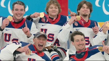 The sled hockey team celebrate holding their medals.